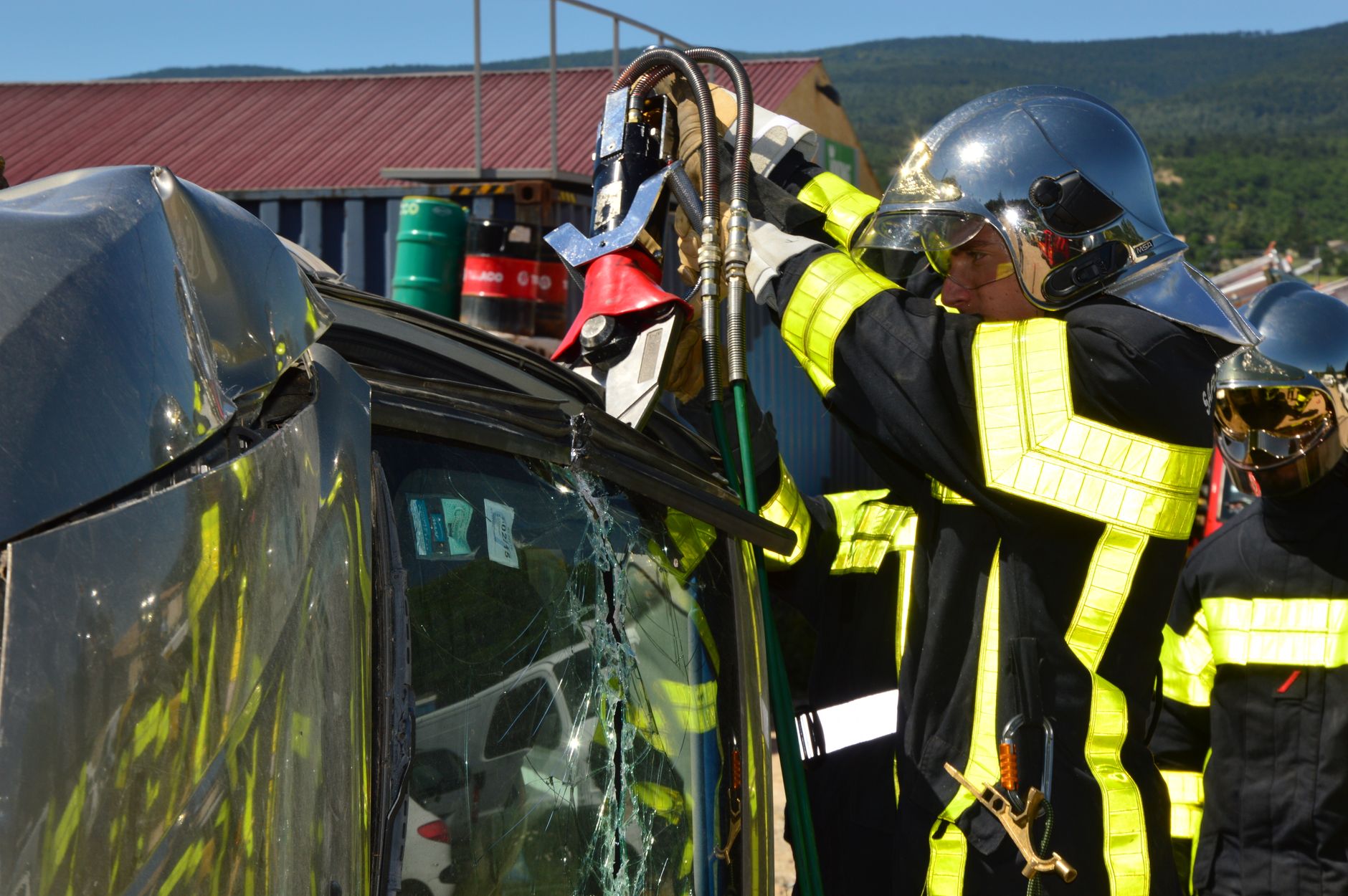 Firefighters in action using rescue tools at a car accident scene outdoors. — wypadek autokaru w Szwajcarii