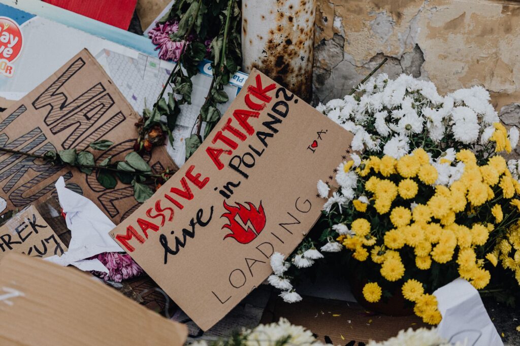 Protest sign with flowers during demonstration in Poland, highlighting social issues. — atak w klasztorze w Jarosławiu
