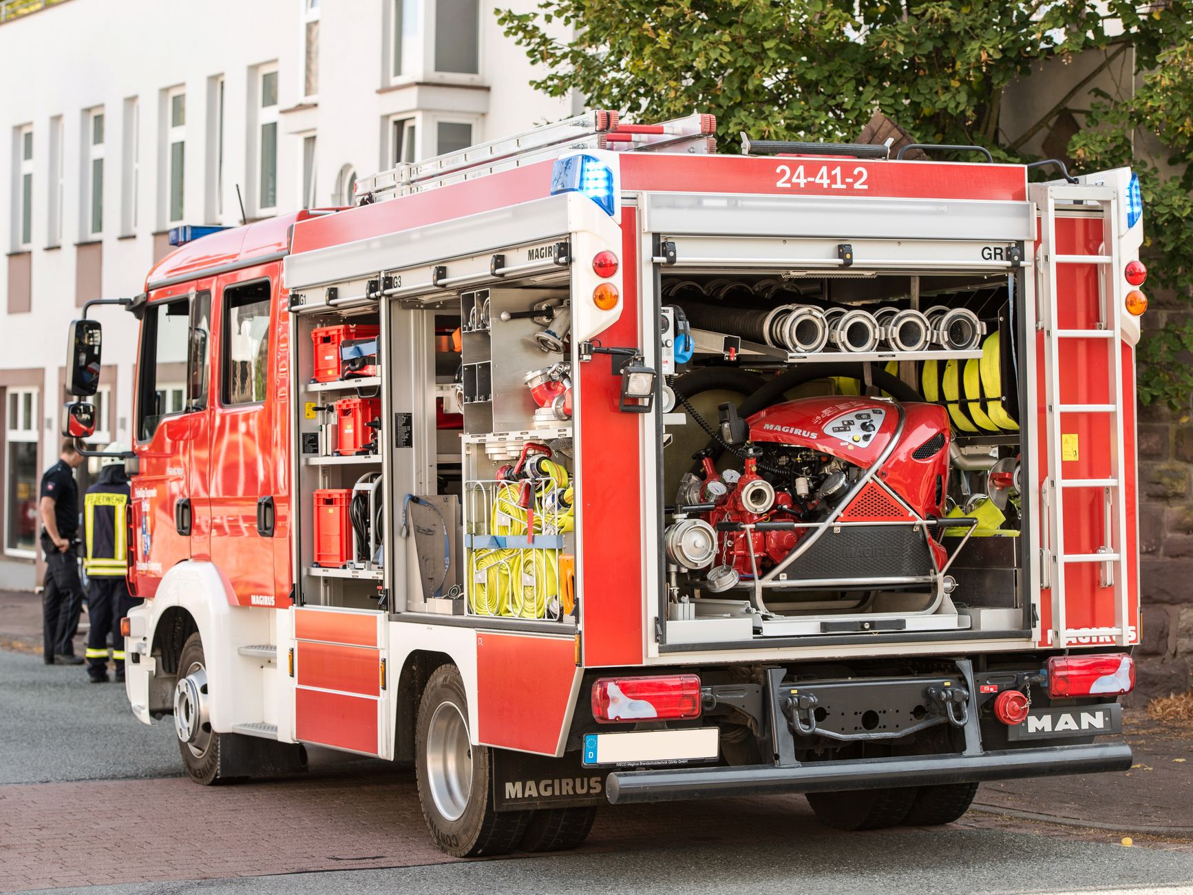 A vibrant red fire truck parked on a city street with equipment visible, showcasing urban emergency — pożar w centrum Białegostoku