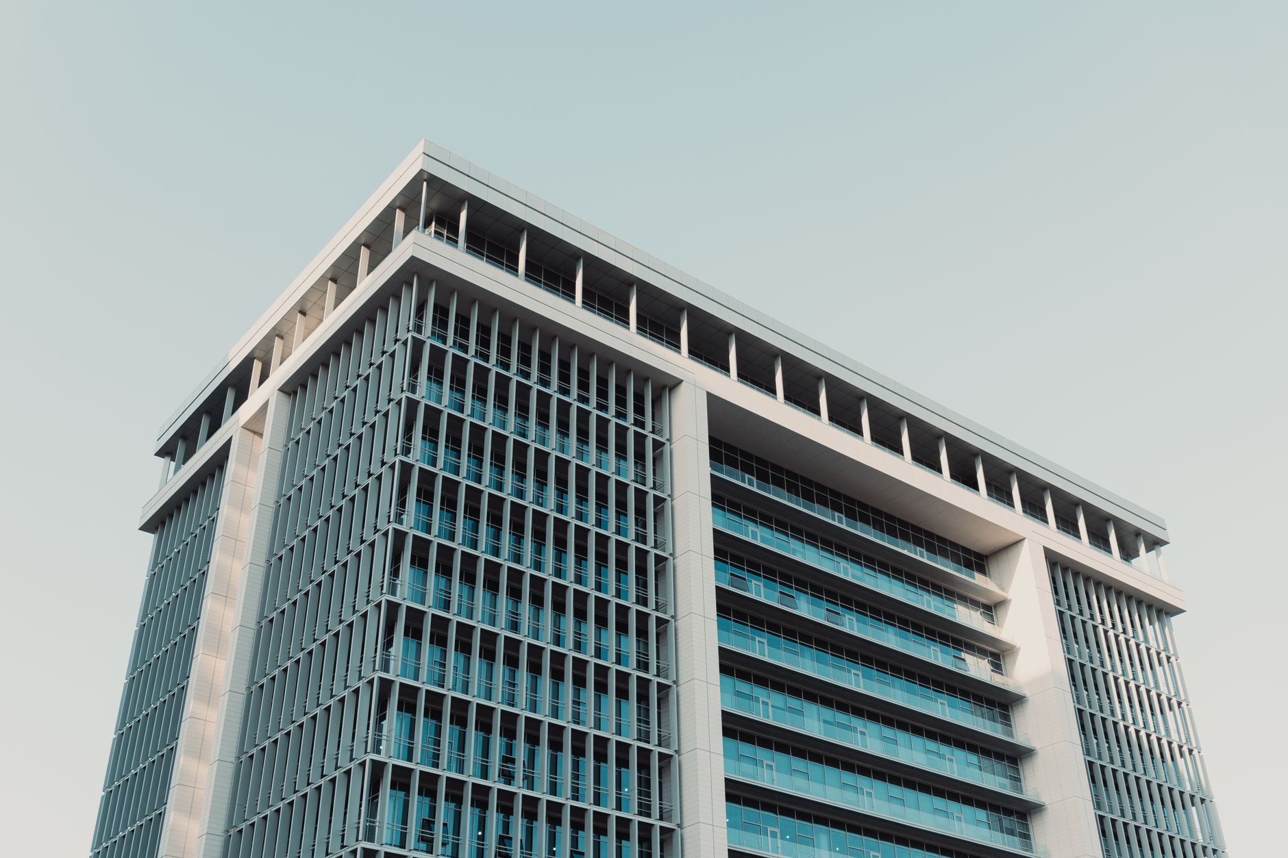 Architectural shot of a modern high-rise office building with a prominent glass facade, shot at daytime. — gospodarka Polski i zamożność