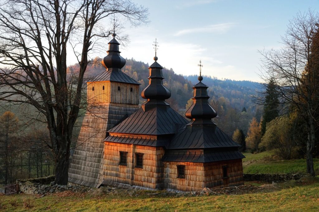 Captivating view of a historic wooden church in Dubne, Poland during a serene sunset. — pogrzeb księdza w Grzęsce