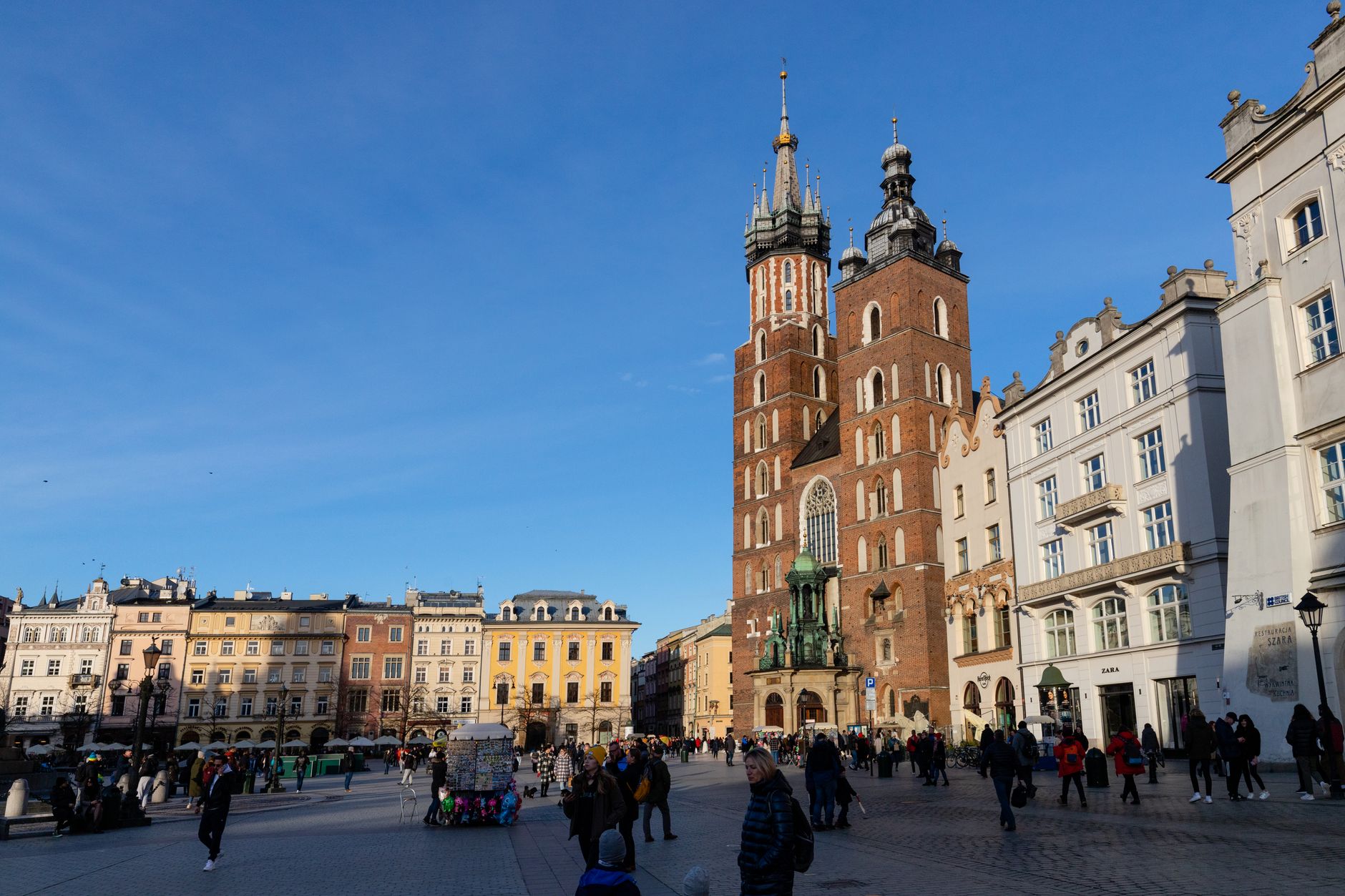 Daytime view of St. Mary's Basilica in Krakow's Main Market Square, under clear blue skies. — spór wyborczy w Krakowie