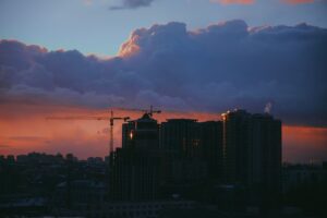 Stunning sunset view of Kyiv skyline with dramatic clouds and construction cranes. — zagrożenie dla Kijowa