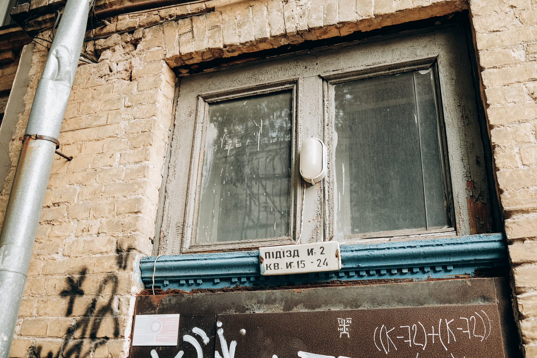 A weathered brick building in Kyiv with graffiti and vintage windows. — rosyjskie ataki na Ukrainę