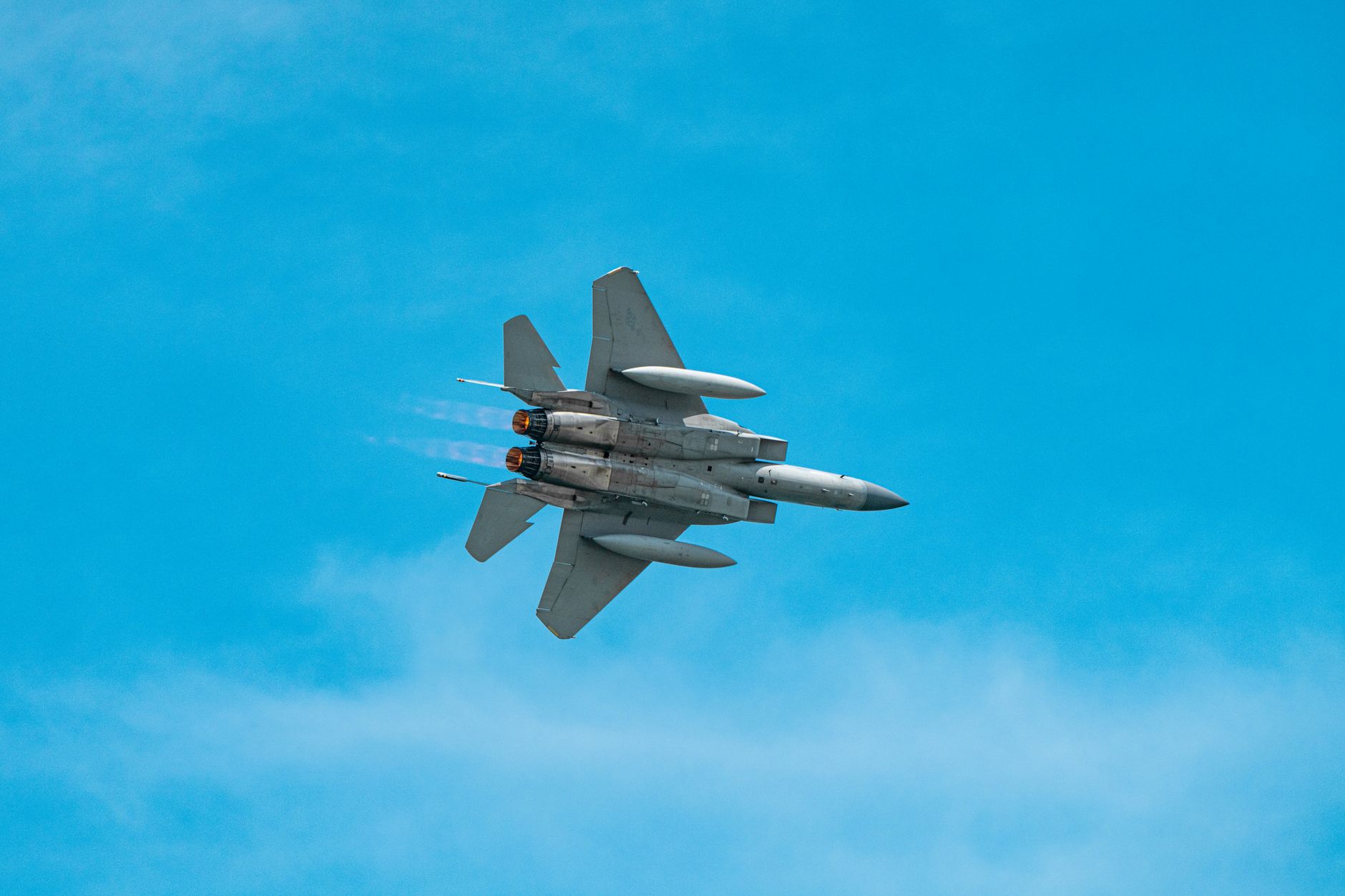 A military jet aircraft soaring through a clear blue sky, showcasing agility and power. — polskie myśliwce obrona powietrzna