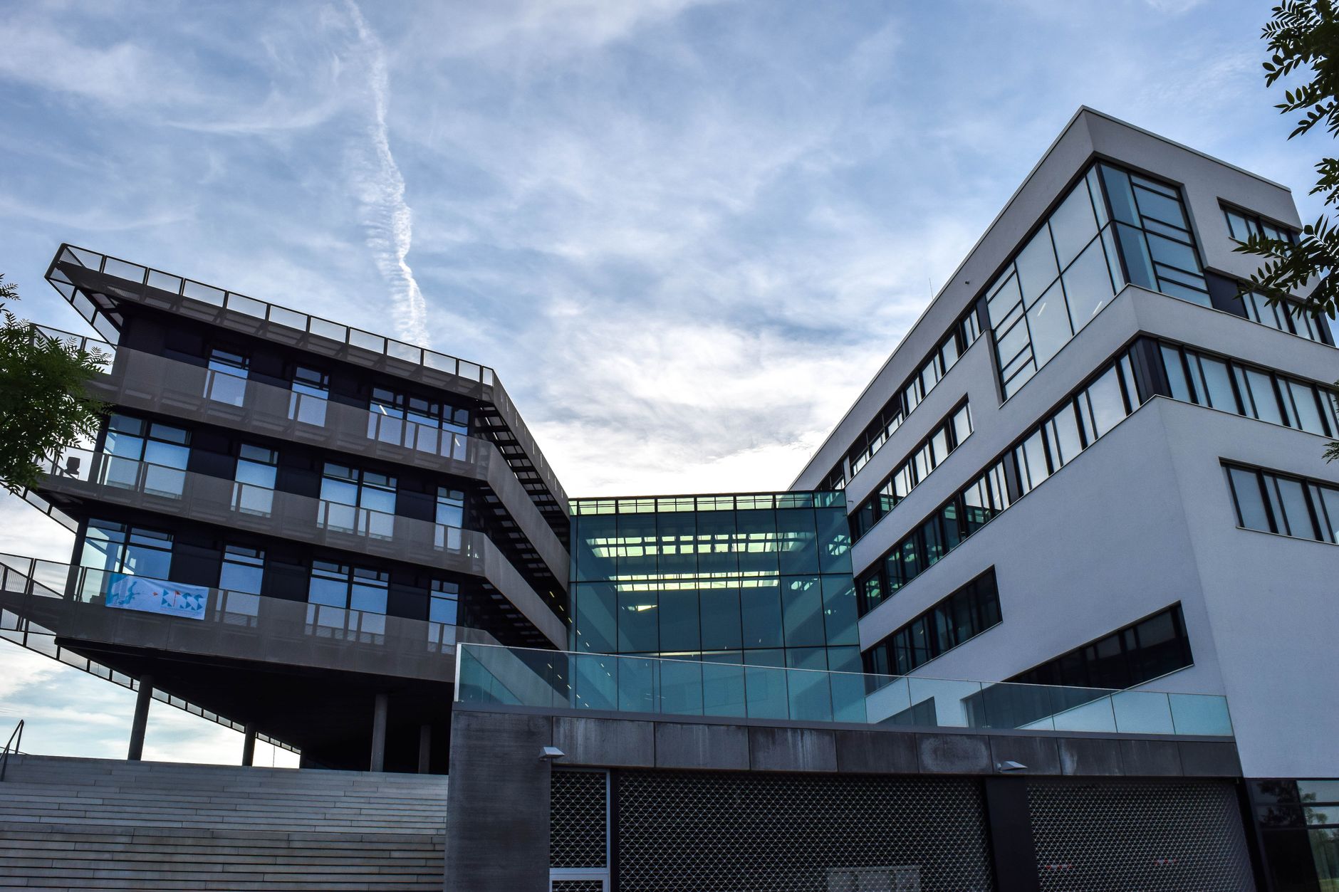 A modern glass-facade building against a blue sky, featuring innovative architecture. — Siedziba Polskiego Komitetu Olimpijskiego