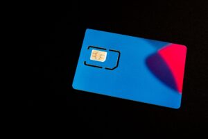 A blue SIM card on a dark background with vibrant red and purple accents. — rosyjskie drony nad Polską