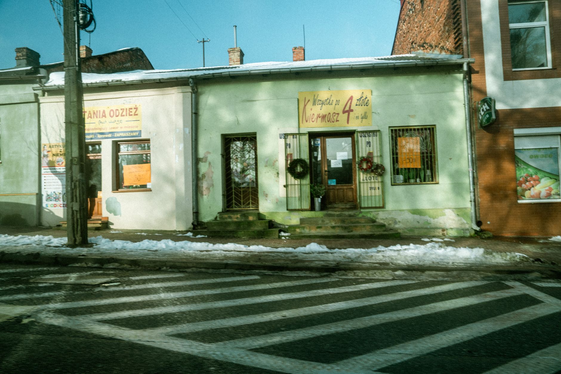 Charming street view of vintage shops on a snowy day, showcasing local architecture. — wybory w Rokietnicy