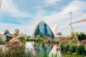 Stunning view of L'Oceanogràfic's modern architecture, surrounded by lush greenery and a tranquil pond in — wcześniejsze wybory w Hiszpanii