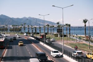 Daytime city traffic along the scenic seafront highway in Izmir, Turkey, with mountain views. — wypadek autokaru w Turcji